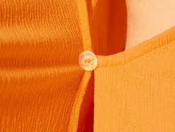 Vestido cruzado de mujer con textura arrugada moderna.